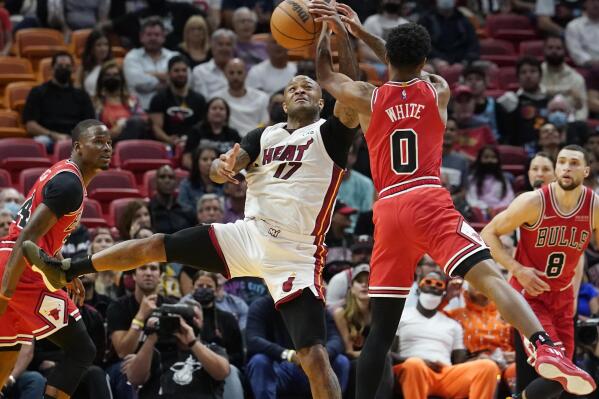 Miami Heat forward P.J. Tucker (17) and Chicago Bulls guard Coby White (0) go after tje ball during the first half of an NBA basketball game Monday, Feb. 28, 2022, in Miami. (AP Photo/Marta Lavandier)
