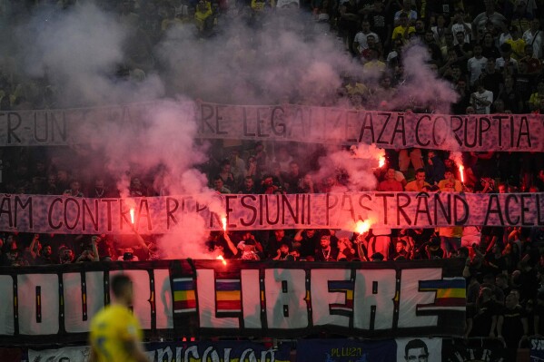 Romanian fans light flares during the Euro 2024 qualifying soccer match between Romania and Israel at the National Arena stadium in Bucharest, Romania, Saturday, Sept. 9, 2023.(AP Photo/Andreea Alexandru)