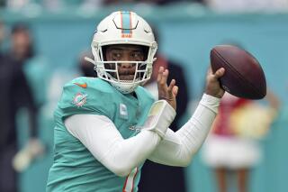 FILE - Miami Dolphins quarterback Tua Tagovailoa looks to pass during the first half of an NFL football game against the Green Bay Packers, Sunday, Dec. 25, 2022, in Miami Gardens, Fla. The first quarterback-specific helmet designed to help reduce concussions has been approved for use by the NFL and NFLPA, the AP has learned. The helmet, manufactured by Vicis, reduces severity of helmet-to-ground impacts, which league data says account for approximately half of quarterback concussions, including the one suffered by Miami’s Tua Tagovailoa last season when his head slammed violently against the turf during a Thursday night game against Cincinnati. (AP Photo/Jim Rassol, File)