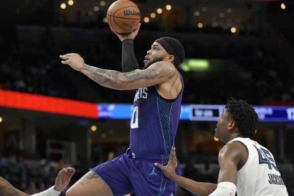 Charlotte Hornets forward Miles Bridges (0) goes up for a dunk ahead next to Memphis Grizzlies forward GG Jackson II (45) during the first half of an NBA basketball game Wednesday, March 13, 2024, in Memphis, Tenn. (AP Photo/Brandon Dill)