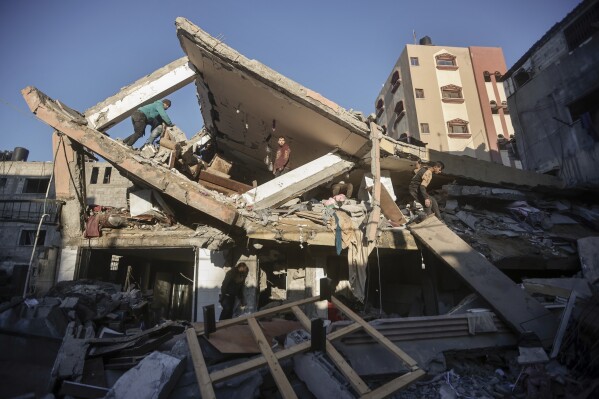Palestinians inspect the damage of a destroyed house following Israeli airstrikes on Khan Younis, Southern Gaza Strip, Sunday, Jan. 7, 2024. (AP Photo/Mohammed Dahman)