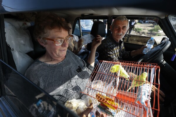 Ethnic Armenians fleeing Nagorno-Karabakh travel with their parrots as they arrive in Kornidzor, in Armenia's Syunik region, Wednesday, Sept. 27, 2023. (AP Photo/Vasily Krestyaninov)