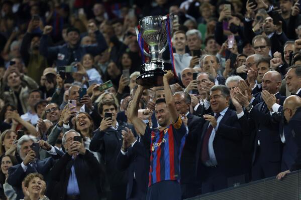Barcelona's team captain Sergio Busquets lifts the championship trophy at the end of a Spanish La Liga soccer match between Barcelona and Real Sociedad at Camp Nou stadium in Barcelona, Spain, Saturday, May 20, 2023. Barcelona clinched the Spanish league title last Sunday with four rounds still to be played.(AP Photo/Joan Monfort)