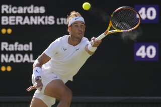 FILE - Spain's Rafael Nadal returns to Lithuania's Ricardas Berankis in a second round men's singles match for the Wimbledon tennis championships in London, June 30, 2022. Nadal is sure he'll be returning to competition after missing nearly all of 2023 with a hip injury that required surgery. And now he says he'll be revealing his comeback plans soon. Nadal wrote Thursday, Nov. 16, 2023 on social media: “I confirmed yesterday I'll be back” and punctuated that message with a smiling emoji. (AP Photo/Kirsty Wigglesworth, file)