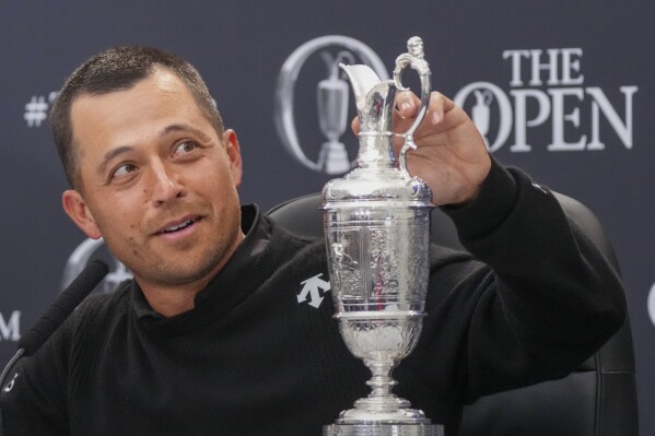 Xander Schauffele of the United States touches the Claret Jug trophy during a press conference after winning the British Open Golf Championships at Royal Troon golf club in Troon, Scotland, Sunday, July 21, 2024. (ĢӰԺ Photo/Jon Super)