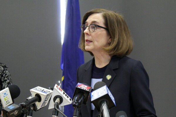FILE - In this March 16, 2020, file photo, Oregon Gov. Kate Brown speaks at a news conference in Portland, Ore. A county judge has declared Brown's coronavirus restrictions "null and void" because she didn't have her emergency orders approved by the Legislature. Baker County Circuit Judge Matthew Shirtcliff made the ruling Monday, May 18, 2020, in a lawsuit brought by churches that had sued saying the social-distancing directives were unconstitutional.(AP Photo/Gillian Flaccus, File)