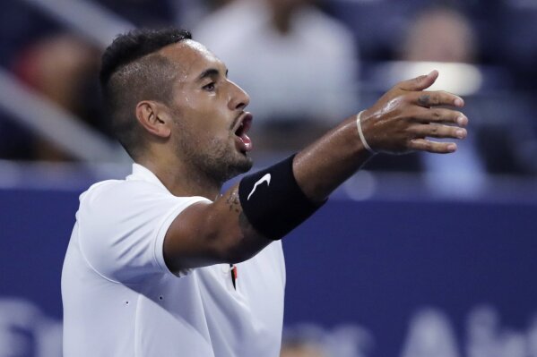 Nick Kyrgios, of Australia, points out distractions in the crowd during his match against Steve Johnson, of the United States, during the first round of the U.S. Open tennis tournament in New York, early Wednesday, Aug. 28, 2019. (AP Photo/Charles Krupa)
