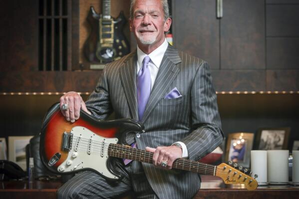 FILE - In this June 10, 2014, file photo, Indianapolis Colts owner and CEO Jim Irsay poses in Indianapolis with the Fender Stratocaster guitar that Bob Dylan played at the Newport Folk Festival in 1965. Irsay is talking with officials in several cities about the possibility of creating a museum to display the pop culture memorabilia that he’s spent millions of dollars collecting over the past 20 years. (Michelle Pemberton/The Indianapolis Star via AP, File)