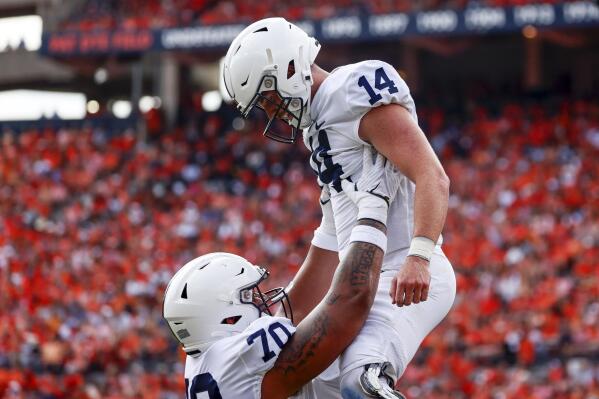 Penn State offensive lineman Juice Scruggs (70) celebrates with Penn State quarterback Sean Clifford (14) after he scored a touchdown against Auburn during the first half of an NCAA college football game, Saturday, Sept. 17, 2022, in Auburn, Ala. (AP Photo/Butch Dill)