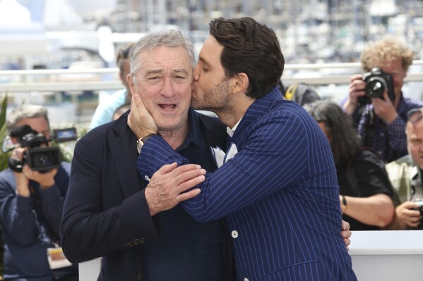 Actor Edgar Ramirez, right, kisses fellow actor Robert De Niro during a photo call for "Hands of Stone" at the 69th international film festival, Cannes, southern France on May 16, 2016. (AP Photo/Joel Ryan, File)
