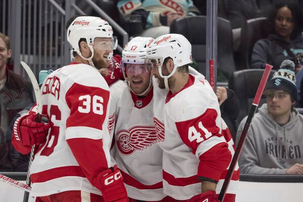 Detroit Red Wings right wing Daniel Sprong second from right, is congratulated by right wing Christian Fischer (36) and defenseman Shayne Gostisbehere (41) after scoring against the Seattle Kraken during the second period of an NHL hockey game, Monday, Feb. 19, 2024, in Seattle. (AP Photo/John Froschauer)