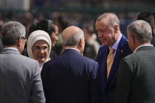 Turkish President and leader of the Justice and Development Party, or AKP, Recep Tayyip Erdogan, right, arrives to vote to a polling station in Istanbul, Turkey, Sunday, March 31, 2024. Turkey is holding local elections on Sunday that will decide who gets to control Istanbul and other key cities. (AP Photo/Khalil Hamra)