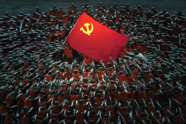Performers dressed as rescue workers gather around the Communist Party flag during a gala show ahead of the 100th anniversary of the founding of the Chinese Communist Party in Beijing on Monday, June 28, 2021. China is marking the centenary of its ruling Communist Party this week by heralding what it says is its growing influence abroad, along with success in battling corruption at home. (AP Photo/Ng Han Guan)