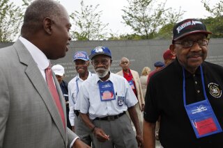 FILE - In this Aug. 3, 2011, file photo, Harry E. Johnson Sr., left, president & CEO of the Martin Luther King Jr. Foundation, takes Tuskegee Airmen, including Theodore Lumpkin Jr., center, and Dabney Montgomery, right, on a tour of the Martin Luther King Jr. Memorial in Washington. Lumpkin has died from complications of the coronavirus, it was announced Friday, Jan. 8, 2021. Lumpkin was just days short of his 101st birthday. Lumpkin, a Los Angeles native, died Dec. 26, according to a statement from Los Angeles City College, which he attended from 1938 to 1940. (AP Photo/Jacquelyn Martin, File)