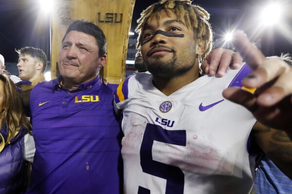 FILE - LSU head coach Ed Orgeron, left, celebrates with running back Derrius Guice (5) following a win over Mississippi in an NCAA college football game Oct. 21, 2017, in Oxford, Miss. LSU and 10 former students who sued the school over alleged mishandling of sexual assault and domestic violence complaints against football players and others at Louisiana’s flagship state university have settled the case, a judge wrote in a March 28, 2024, order. Four of the the plaintiffs in the 2021 civil case accused former star running back Guice of sexual misconduct. (AP Photo/Rogelio V. Solis, File)