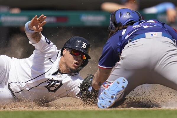 Detroit Tigers' Javier Baez slides safely to score ahead of the tag of Texas Rangers catcher Jonah Heim at home plate in the fifth inning of a baseball game in Detroit, Sunday, June 19, 2022. (AP Photo/Paul Sancya)