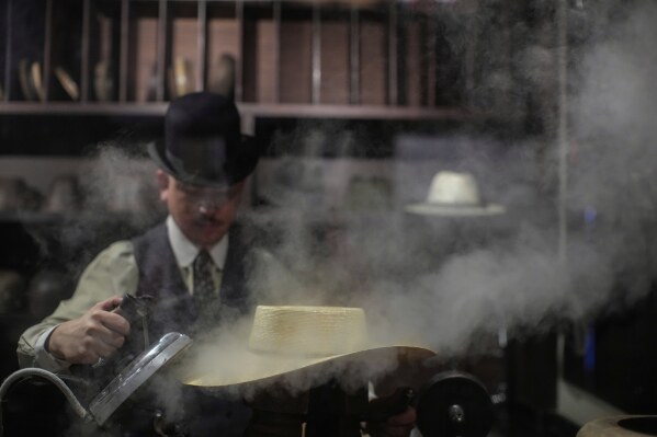 Enzo Restovic steams a hat at "Donde Golpea el Monito" hat shop and museum, in Santiago, Chile, April 5, 2025, which preserves a hat-making tradition dating back to 1915. (AP Photo/Esteban Felix)