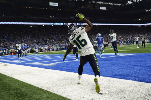 Seattle Seahawks wide receiver Tyler Lockett (16) celebrates after catching a 3-yard touchdown pass during the second half of an NFL football game against the Detroit Lions, Sunday, Sept. 17, 2023, in Detroit. (AP Photo/Paul Sancya)