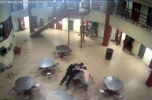 In this Saturday, March 27, 2021, image taken from video released Friday, April 2, 2021, by the Oklahoma City Police Department from the Oklahoma County Detention Center, a jailer is attacked by an inmate before police shoot and kill another inmate who was holding a homemade knife to the jailer's neck. Police Chief Wade Gourley showed portions of graphic jail video to reporters on Friday, including video that shows inmates beating and stabbing the jailer, whose hands were tied behind his back. (Oklahoma County Detention Center/Oklahoma City Police Department via AP)