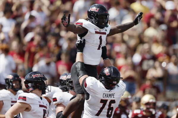 Northern Illinois running back Antario Brown (1) is lifted by offensive lineman John Champe (76) as he celebrates his touchdown during the first half of an NCAA college football game against Boston College, Saturday, Sept. 2, 2023, in Boston. (AP Photo/Michael Dwyer)