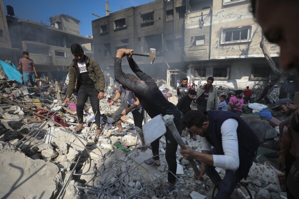 FILE - Palestinians search for survivors after an Israeli strike on the Gaza Strip in Nusseirat refugee camp, central Gaza Strip, Nov. 17, 2023. Workers from the State Department to the Pentagon have endorsed open letters demanding President Joe Biden pursue a cease-fire in the Israel-Hamas war. Congressional staffers have spoken out from the Capitol against what they say is their bosses' silence on the war's toll among Palestinian civilians. It's an unusual public challenge from within the government to the strong U.S. support for Israel's offensive. (AP Photo/Marwan Saleh, File)