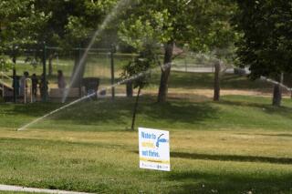 Sprinklers run at Reservoir Park in the middle of the afternoon heat during peak evaporations times on Monday afternoon, July 19, 2021, near the University of Utah campus in Salt Lake City. (Francisco Kjolseth/The Salt Lake Tribune via AP)