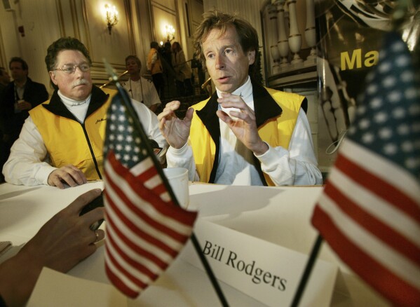 Four-time Boston Marathon winner, Bill Rodgers, speaks, as Boston Marathon wheelchair winner and pioneer, Bob Hall, listens at left, during a news conference in Boston, April 15, 2005. (AP Photo/Elise Amendola, File)