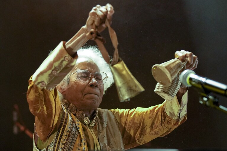 FILE - Brazilian singer Catia de Franca, 77, performs using Afro-Brazilian rattles known as caxixis and a cow bell at a warehouse converted into a venue for independent artists in Sao Paulo, Brazil, April 19, 2024. It took almost half a century for de França to find her audience. Her belated fame largely reflects a revival taking place in Brazil, where vinyl records outsold CDs and DVDs for the first time last year. (AP Photo/Andre Penner, File)