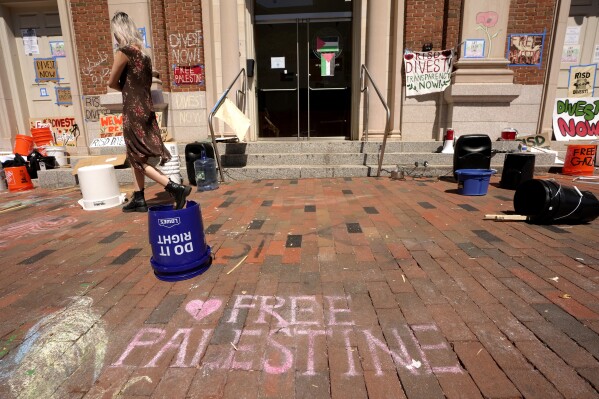 A passer-by walks past an entrance to a building at Rhode Island School of Design, Tuesday, May 7, 2024, in Providence, R.I. Student activists and supporters, who have taken over a portion of the building, are demanding that the school condemn Israel's war effort in Gaza, and that the school divest from investments that benefit Israel. (AP Photo/Steven Senne)
