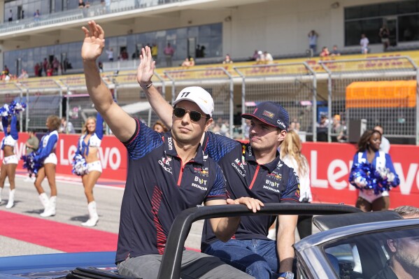 Red Bull driver Sergio Perez, of Mexico, left, and Red Bull driver Max Verstappen, of the Netherlands, wave during the drivers parade in the Formula One U.S. Grand Prix auto race at Circuit of the Americas, Sunday, Oct. 22, 2023, in Austin, Texas. (AP Photo/Darron Cummings)