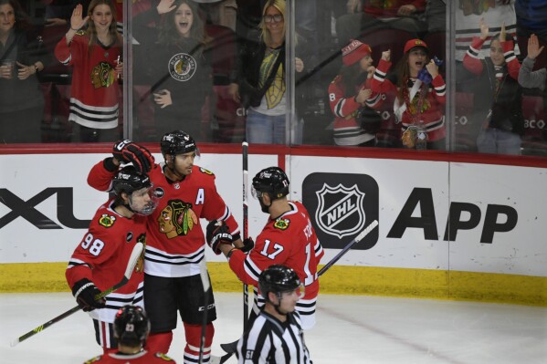 Chicago Blackhawks' Seth Jones (4) celebrates with teammates Nick Foligno (17) and Connor Bedard (98) after scoring a goal during the second period of an NHL hockey game against the Anaheim Ducks Tuesday, March 12, 2024, in Chicago. (AP Photo/Paul Beaty)