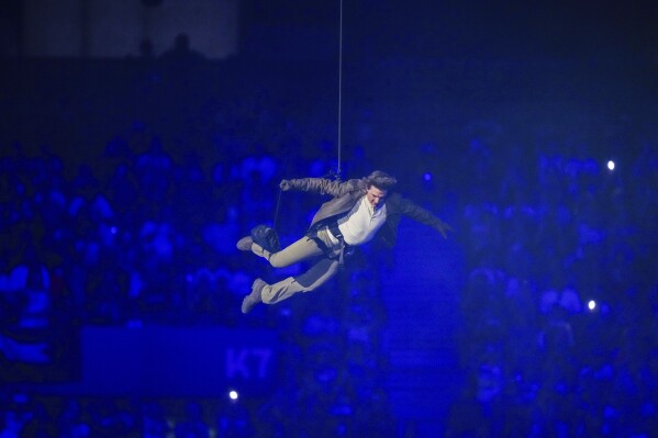 Tom Cruise is lowered on the State de France during the 2024 Summer Olympics closing ceremony, Sunday, Aug. 11, 2024, in Saint-Denis, France. (AP Photo/Natacha Pisarenko)