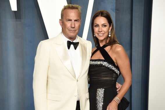 FILE - Kevin Costner, left, and Christine Baumgartner arrive at the Vanity Fair Oscar Party on March 27, 2022, in Beverly Hills, Calif. Costner and Baumgartner have reached a settlement in their divorce. The couple said in a joint statement that they have come to an amicable resolution to all the issues surrounding their split. (Photo by Evan Agostini/Invision/AP, File)