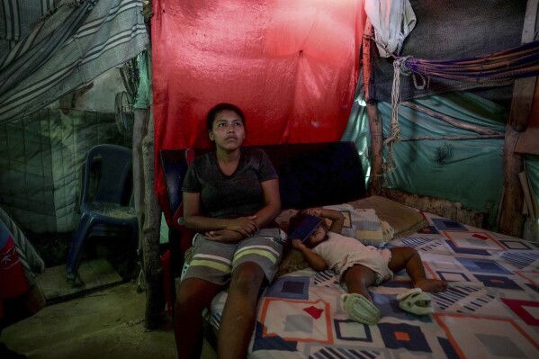 Luciane Mengual, 22, an Indigenous woman from the Wayuu community, poses with her baby at home in the Villa del Sur neighborhood, on the outskirts of Riohacha, Colombia, Tuesday, Feb. 4, 2025. (AP Photo/Ivan Valencia)