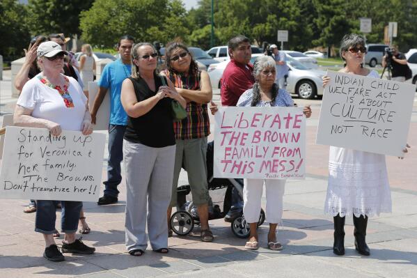 FILE - Participants listen during a rally in support of three-year-old baby Veronica, Veronica's biological father, Dusten Brown, and the Indian Child Welfare Act, in Oklahoma City, Monday, Aug. 19, 2013. Brown is trying to maintain custody of the girl who was given up for adoption by her birth mother to Matt and Melanie Capobianco of South Carolina. The U.S. Supreme Court will hear arguments, Wednesday, Nov. 9, 2022 on the most significant challenge to the Indian Child Welfare Act that gives preference to Native American families in foster care and adoption proceedings of Native American children since it passed in 1978. (AP Photo/Sue Ogrocki, File)