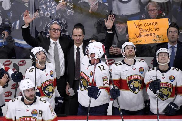 Florida Panthers coach Paul Maurice, left, and assistant coach Jamie Kompon wave to fans during a break in the action against the Winnipeg Jets during the first period of an NHL hockey game Tuesday, Dec. 6, 2022, in Winnipeg, Manitoba. (Fred Greenslade/The Canadian Press via AP)