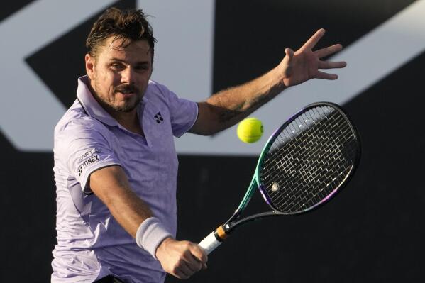Stan Wawrinka of Switzerland plays a backhand return to Alex Molcan of Slovakia during their first round match at the Australian Open tennis championship in Melbourne, Australia, Monday, Jan. 16, 2023. (AP Photo/Ng Han Guan)