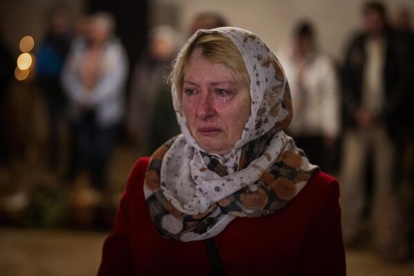 Olga Zhovtobrukh, 55, cries during an Easter religious service celebrated at a church in Bucha, on the outskirts of Kyiv, on Sunday, April 24, 2022. (AP Photo/Emilio Morenatti)