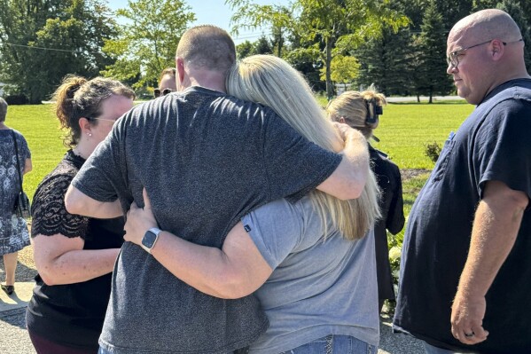 Shannon Doughty and her cousin, Eric Pranger, embrace on Aug. 29, 2024, in Westfield, Indiana, during the dedication of a memorial to the known victims of suspected serial killer Herbert Baumeister, including Doughty's brother, Allen Livingston. (AP Photo/Rick Callahan)