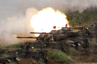 FILE- In this Tuesday, May 25, 2017, file photo, a line of U.S. M60A3 Patton tank fire at targets during the annual Han Kuang exercises on the outlying Penghu Island, Taiwan. Beijing has strongly protested a U.S. plan to sell $1.4 billion worth of arms to Taiwan and demanded that the deal be canceled. Chinese foreign ministry spokesman Lu Kang on Friday said Washington should immediately stop the sale to avoid harming relations with Beijing. (AP Photo/Chiang Ying-ying, File)