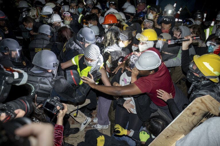 Police advance on pro-Palestinian demonstrators on the UCLA campus in Los Angeles on Thursday, May 2, 2024.  (AP Photo/Ethan Swope)