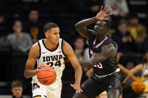 Iowa forward Kris Murray (24) drives around Omaha forward Akol Arop (33) during the first half of an NCAA college basketball game, Monday, Nov. 21, 2022, in Iowa City, Iowa. (AP Photo/Charlie Neibergall)