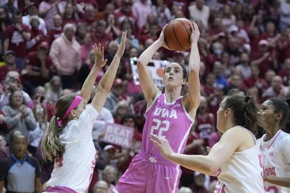Iowa's Caitlin Clark (22) shoots against Indiana's Sara Scalia (14) and Mackenzie Holmes (54) during the first half of an NCAA college basketball game Thursday, Feb. 9, 2023, in Bloomington, Ind. (AP Photo/Darron Cummings)