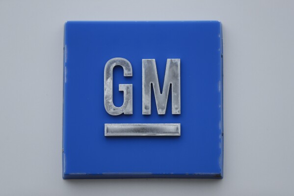 FILE - A GM logo is shown at the General Motors Detroit-Hamtramck Assembly plant in Hamtramck, Mich., Jan. 27, 2020. General Motors has hired a former Tesla executive, Kurt Kelty, to serve in the newly created role of vice president of Batteries as the automaker continues to work on its electric vehicle strategy. Kelty will be charged with GM’s battery cell strategy and a new end-to-end approach. (AP Photo/Paul Sancya, file)