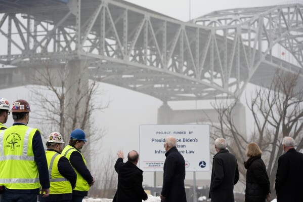 President Joe Biden speaks with Craig Thompson, Secretary, Wisconsin Department of Transportation, center left, as they look toward the John A. Blatnik Bridge between Duluth, Minn., and Superior, Wis., Thursday, Jan. 25, 2024, in Superior, Wis. Biden is returning to the swing state of Wisconsin to announce $5 billion in federal funding for upgrading the Blatnik Bridge and for dozens of similar infrastructure projects nationwide. (AP Photo/Alex Brandon)