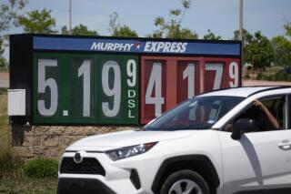 Gasoline prices are displayed outside a convenience store as a motorist drives by, Thursday, May 26, 2022, in Thornton, Colo. Experts are expecting a flush of travelers at airports and on the nation's byways during the long Memorial Day weekend, which marks the start of the summer travel season, in spite of high fuel costs. (AP Photo/David Zalubowski)