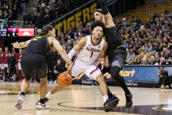 Alabama's Mark Sears, center, has the ball stripped as he drives between Missouri's Noah Carter, right, and Tre Gomillion during the first half of an NCAA college basketball game Saturday, Jan. 21, 2023, in Columbia, Mo. (AP Photo/L.G. Patterson)