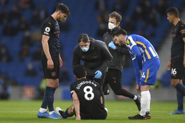 Manchester City's Ilkay Gundogan sits on the pitch after an injury during the English Premier League soccer match between Brighton & Hove Albion and Manchester City at the Amex stadium in Brighton, England, Tuesday, May 18, 2021. (Mike Hewitt, Pool via AP)