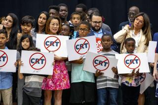 Kids holding signs against Critical Race Theory stand on stage near Florida Gov. Ron DeSantis as he addresses the crowd before publicly signing HB7 at Mater Academy Charter Middle/High School in Hialeah Gardens, Fla., on April 22, 2022. Republican groups that sought to get hundreds of “parents’ rights” activists elected to local school boards largely fell short in Tuesday’s elections. The push has been boosted by Republican groups including the 1776 Project PAC, but just a third of its roughly 50 candidates won. (Daniel A. Varela/Miami Herald via AP, file)