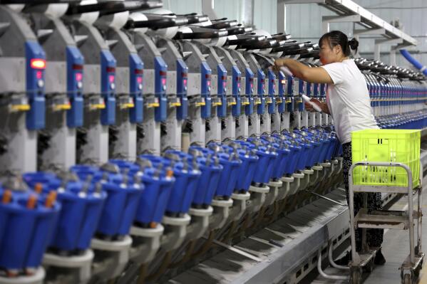 A woman works in a textile factory in Human in eastern China's Shandong Province, Nov. 1, 2022. Chinese consumer spending contracted in October and factory activity weakened as anti-virus controls following a rise in infections weighed on the economy. (Chinatopix via AP)